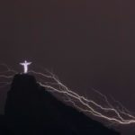 Lightning flashes over the Christ the Redeemer statue on top of Corcovado Hill in Rio de Janeiro on January 14, 2014.    AFP PHOTO / YASUYOSHI CHIBA