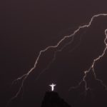 Lightning flashes over the Christ the Redeemer statue on top of Corcovado Hill in Rio de Janeiro on January 14, 2014.    AFP PHOTO / YASUYOSHI CHIBA